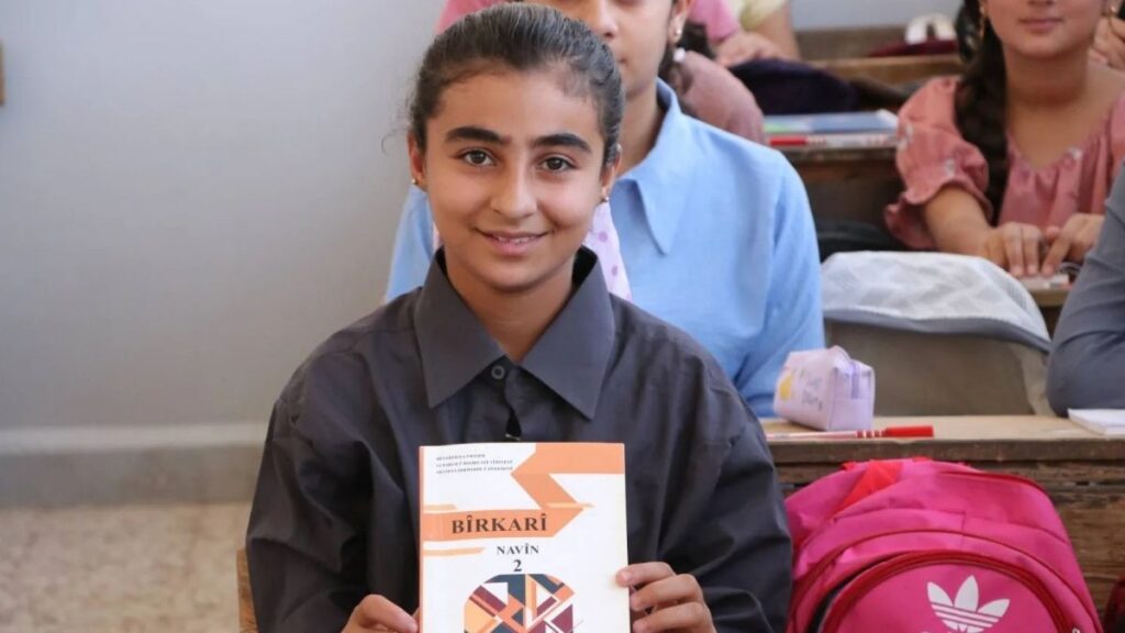 A Kurdish student holds a mathematics textbook written in her mother tongue, February 10, 2024. (Asharq Al-Awsat)