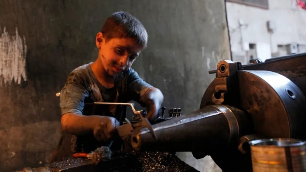 A Syrian child works on an industrial machine, December 22, 2025. (Reuters)