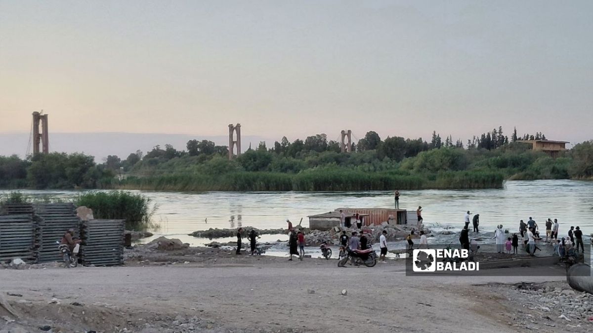 Residents in Deir Ezzor swim near the earthen bridge on the banks of the Euphrates River, June 4, 2026. (Enab Baladi/Shaymaa al-Saleh)