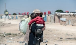 A woman bathes a child at a camp for displaced people near Sarmada in Idlib governorate, northwestern Syria, June 28, 2024. (AFP)
