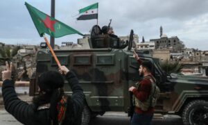 SDF fighters wave the flag of the Women’s Protection Units as Syrian army forces enter Qamishli (northeastern Syria) following the integration agreement, February 3, 2026. (AFP)