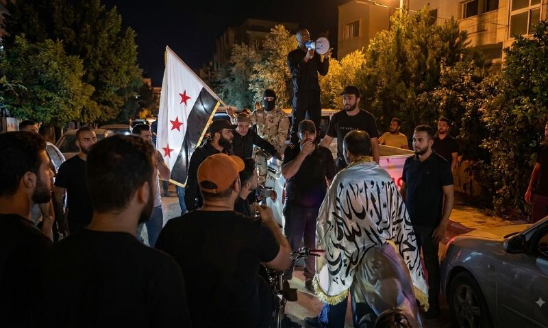 Activists take part in a protest outside the home of Syrian businessman Mohammad Hamsho, who was close to the former regime, in Qura al-Sham near al-Saboura in the Damascus countryside, August 11, 2026. (Omar Nazhat/Screenshot)