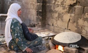 Ruwayda Abdul Majid al-Nakash prepares saj bread in Darayya.