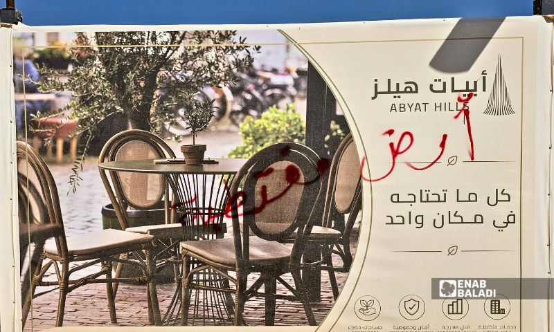 One of the “Abyat Hills” project signs after protesters wrote slogans on it during the demonstration, September 26, 2026. (Enab Baladi/Ahmad Maslamani)