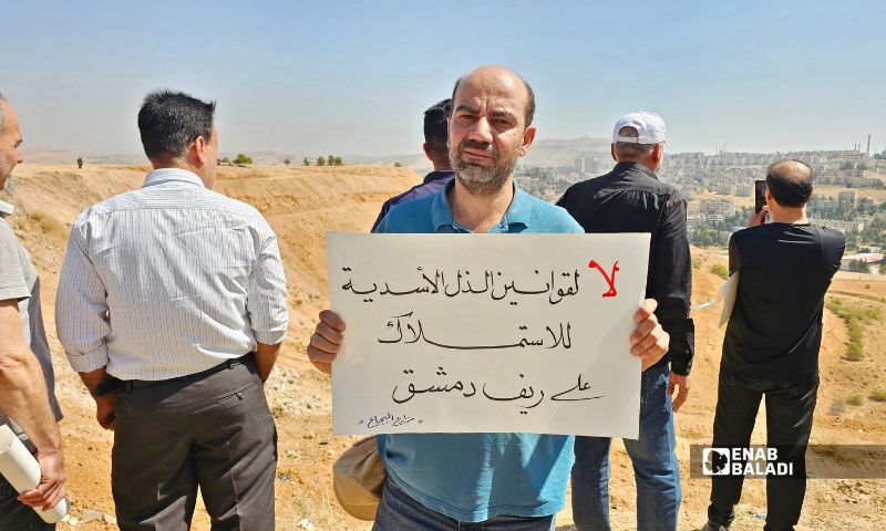 Protesters raised signs addressing land ownership and owners’ rights during the demonstration, September 26, 2026 (Enab Baladi/Ahmad Maslamani). 