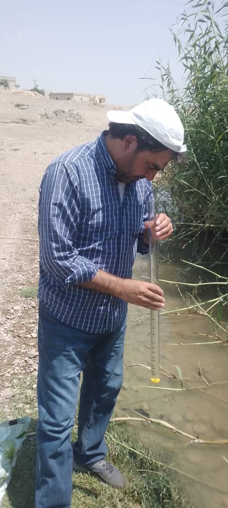 Environmental researcher Ahmed al-Wajid taking field measurements at the Balikh River in Raqqa governorate