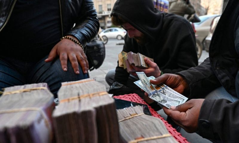 A makeshift currency exchange stall on a street in the Syrian capital, Damascus, January 17, 2025 (AFP).